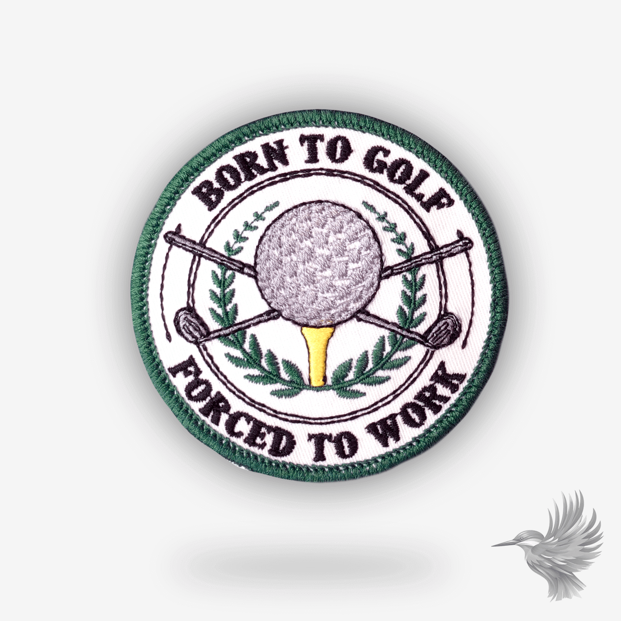 Rundt broderet patch med teksten “Born to Golf, Forced to Work” – golfbold, tee og krydsede golfkøller i midten