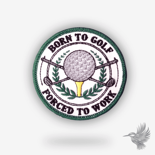 Rundt broderet patch med teksten “Born to Golf, Forced to Work” – golfbold, tee og krydsede golfkøller i midten
