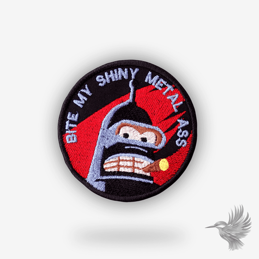 Rundt broderet patch med Bender fra Futurama og teksten “Bite My Shiny Metal Ass” – sort og rød baggrund