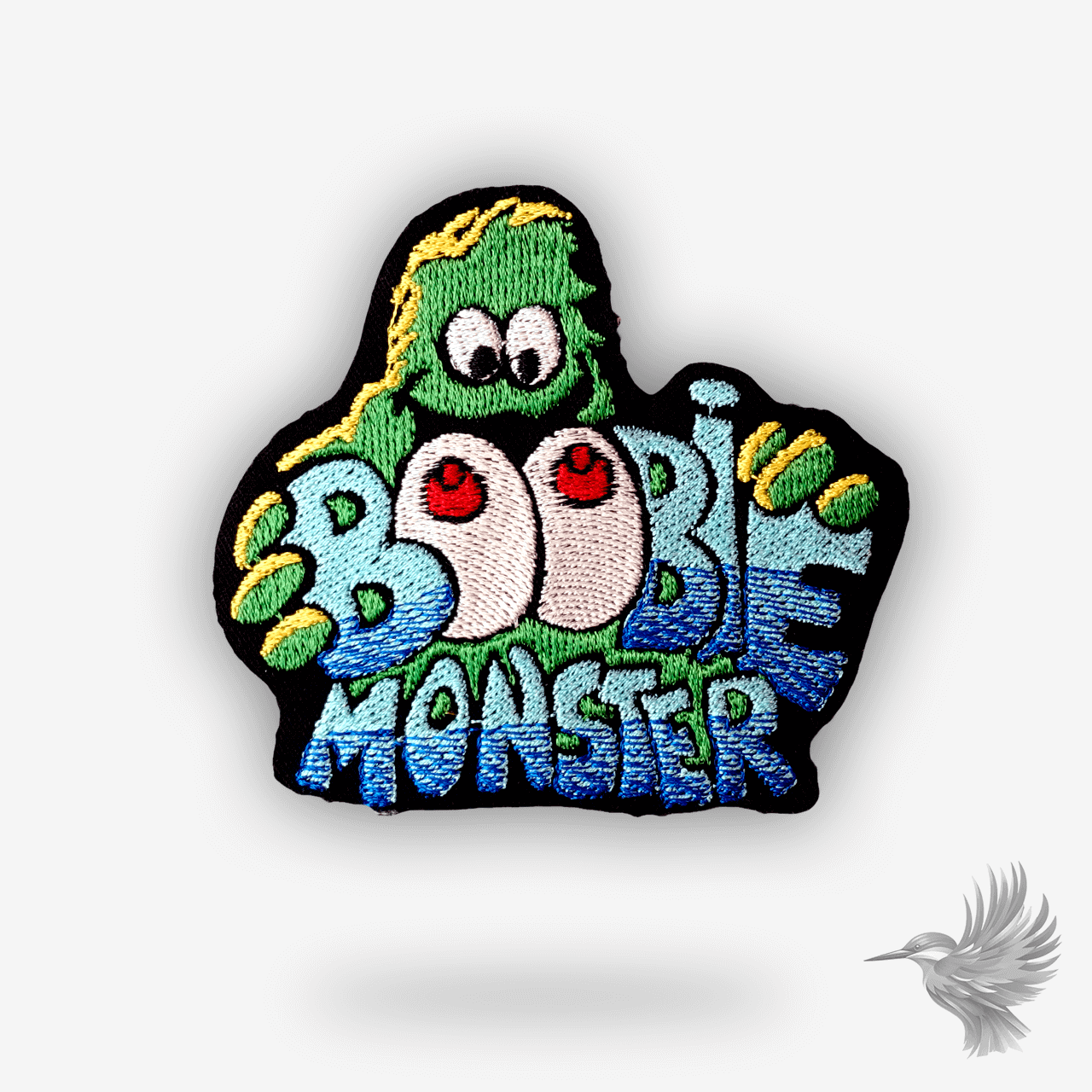 Broderet patch med farverigt monster og teksten “Boobie Monster” – humoristisk design med bryster i cartoon-stil