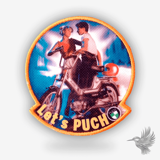Broderet patch med et ungt par på PUCH-knallert og teksten “Let’s PUCH” – retro design med neonlys og orange kant