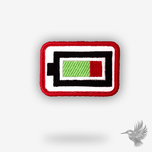 Broderet strygemærke formet som et lavt batteri-ikon i sort, hvid, grøn og rød – sjovt og minimalistisk patch