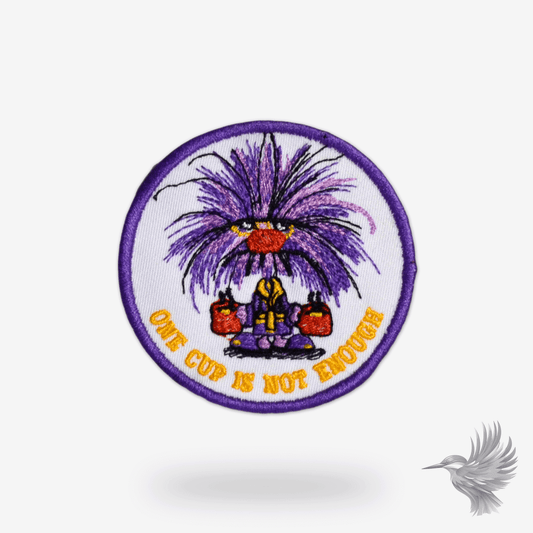 sjovt strygemærke med kaffe med tekst "One Cup Is Not Enough" og figur med kopper kaffe.