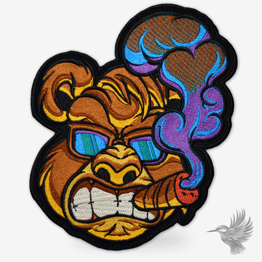 Cigar smoking bear patch symærke with sunglasses and cigar, showcasing vibrant colors and detailed embroidery.