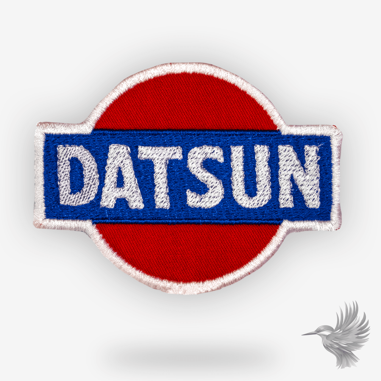 Datsun logo patch strygemærke broderet bilmærke i retrostil på rød baggrund med blå ramme.