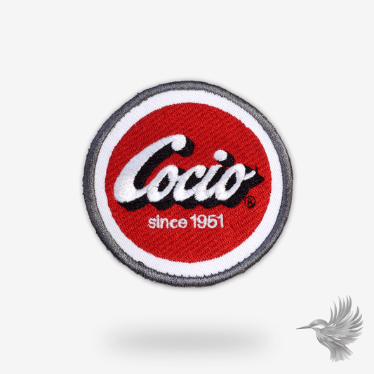 Broderet Cocio stofmærke i ikonisk rød og gul farve – perfekt til jakker, tasker og caps.