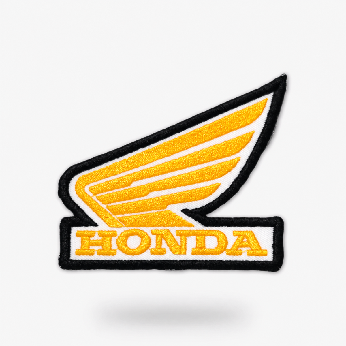 Honda strygemærke i sort og gul på lys baggrund