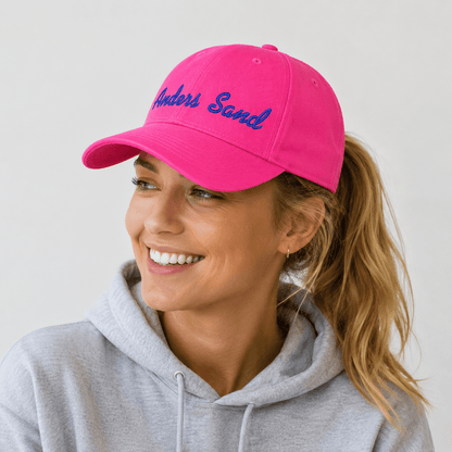 Pink CAP Kasket med Egen Tekst og Broderi på en glad kvinde med en grå hættetrøje.