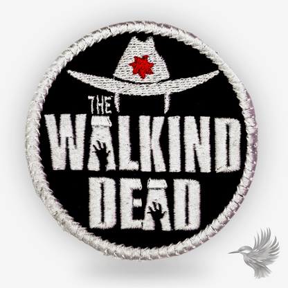 The Walking Dead Canada patch strygemærke med sort baggrund, cowboyhat og rødt ahornblad, der repræsenterer canadisk identitet.